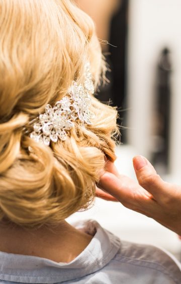 Hair stylist makes the bride before a wedding